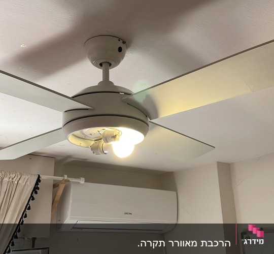 מאוורר תקרה עם מנורה דולקת בחדר